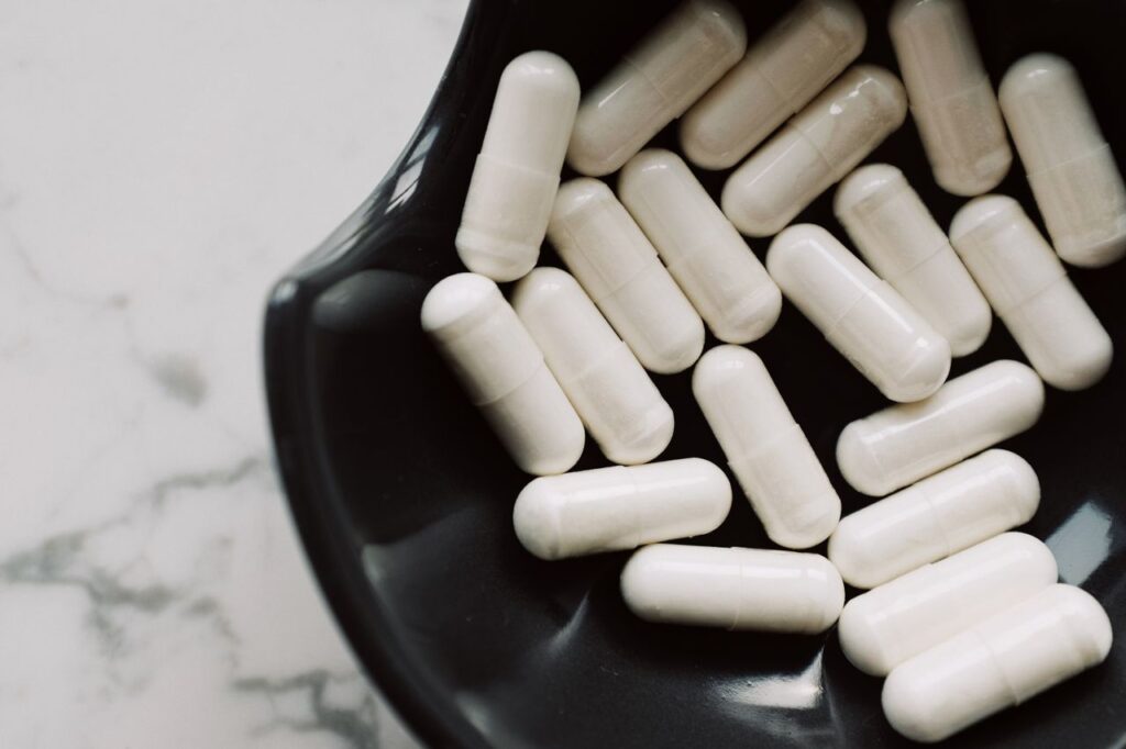 White capsules in a black ceramic bowl