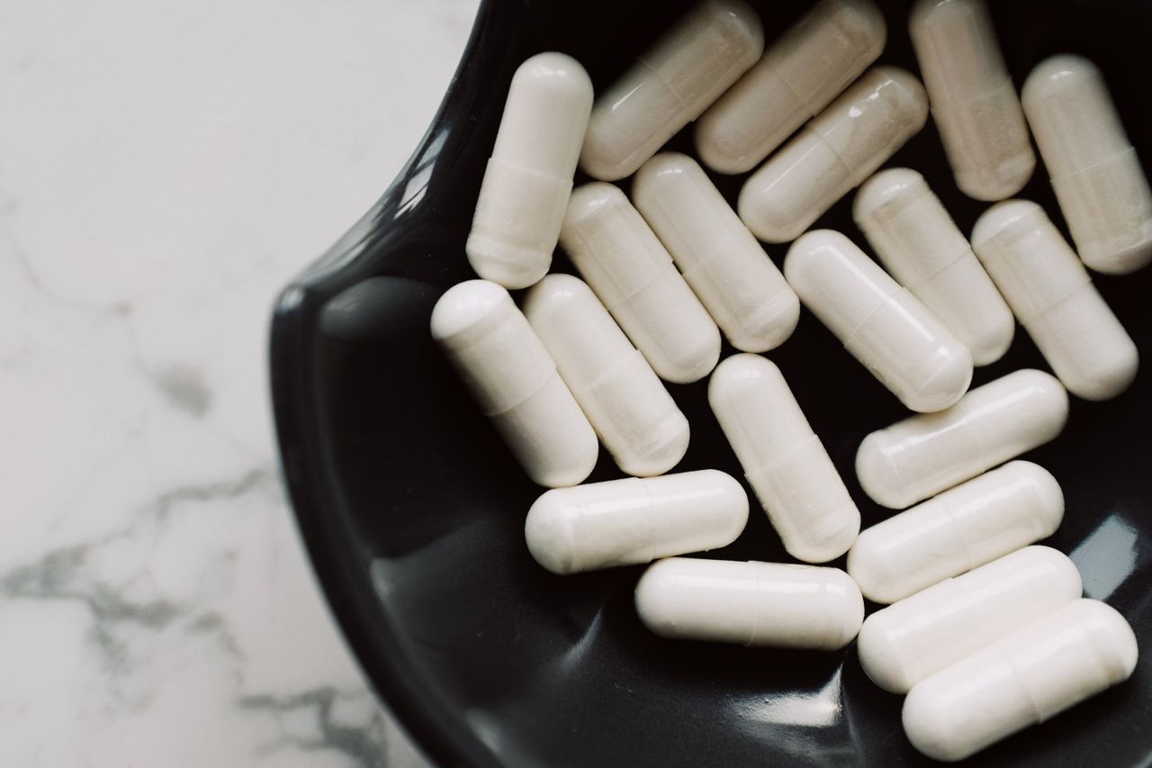 White capsules in a black ceramic bowl