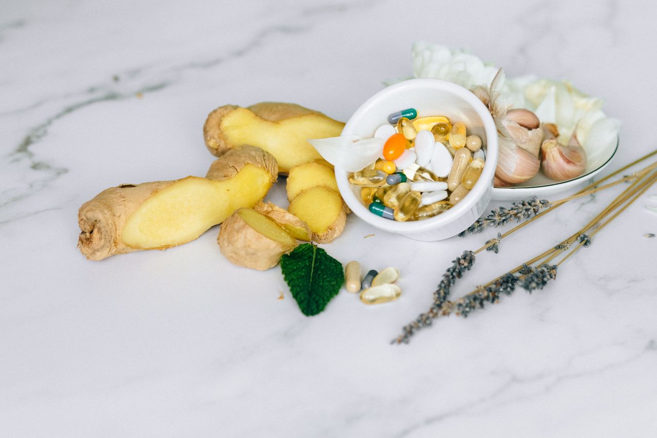 Ginger, garlic and herbal supplements arranged on marble
