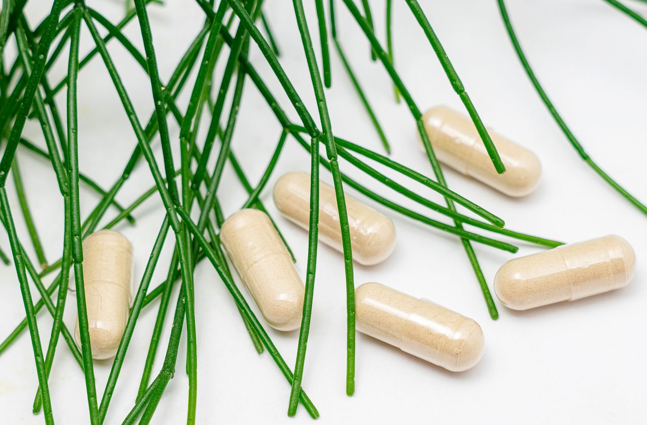 Beige capsules surrounded by green leaves