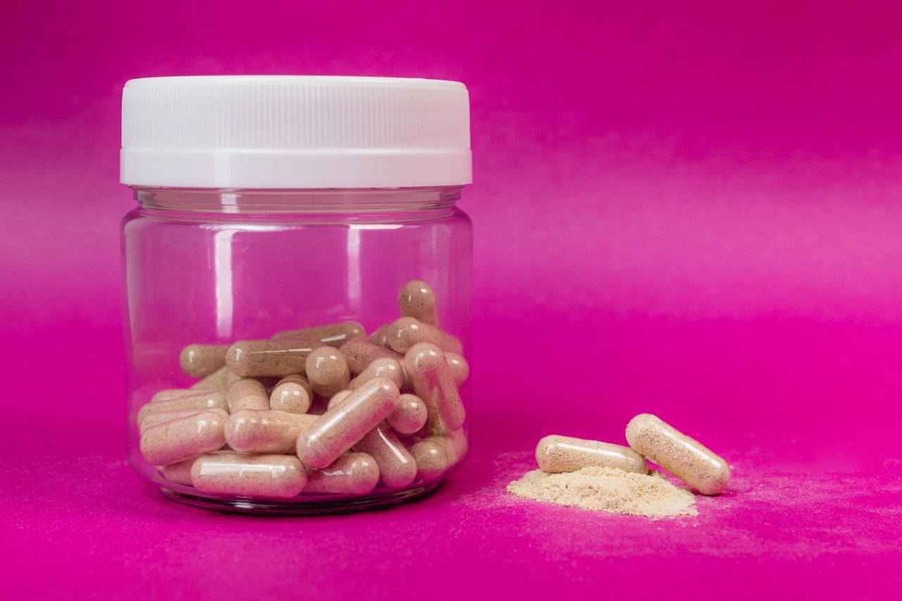 Jar of brown capsules and loose powder