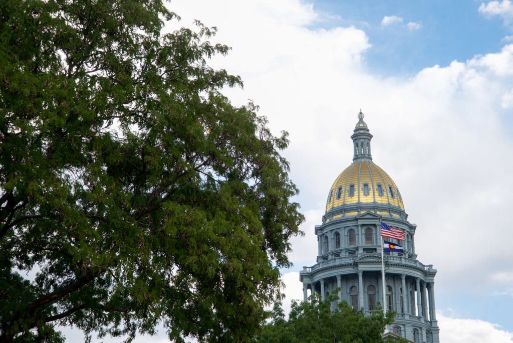 The Denver State Capitol building with its iconic gold dome under a clear blue sky