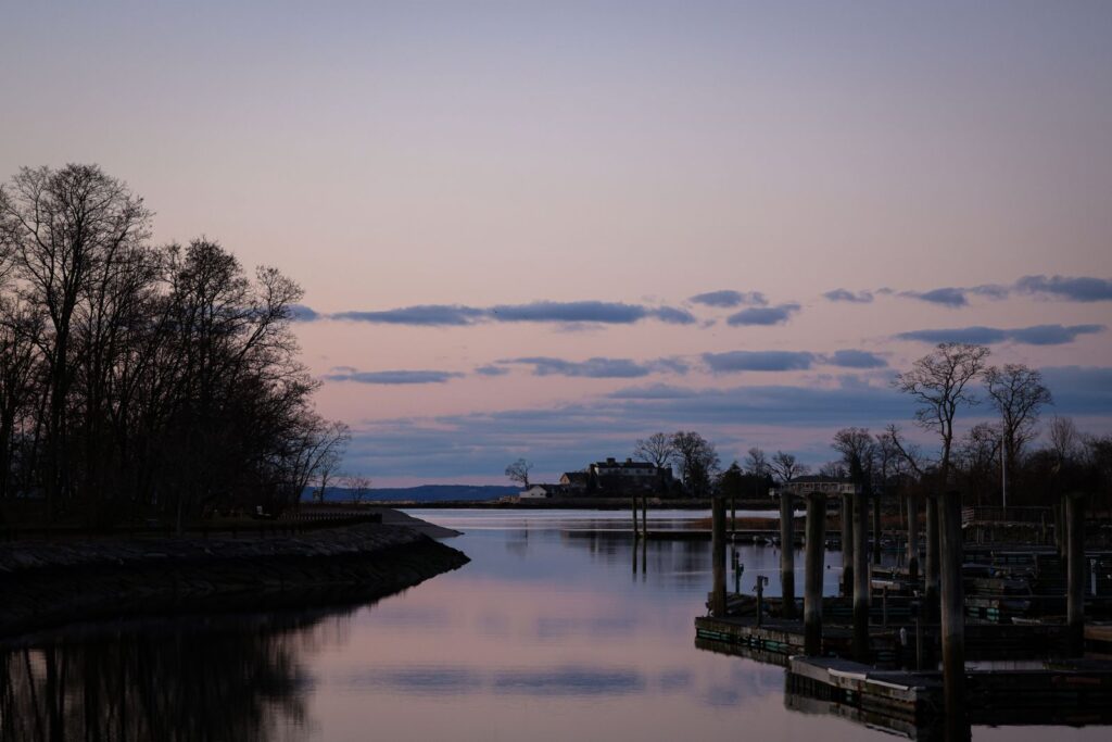 A serene dusk view of the waterfront in Stamford, CT, with calm waters