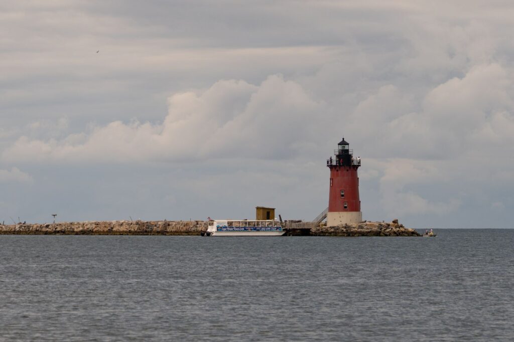 Cape Henlopen lighthouse overlooking the ocean with cloudy skies in Lewes,