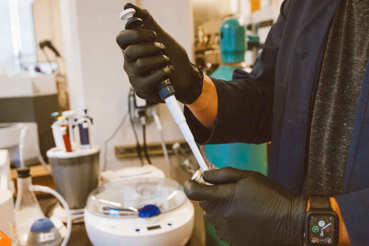 Lab technician performing an experiment with a pipette