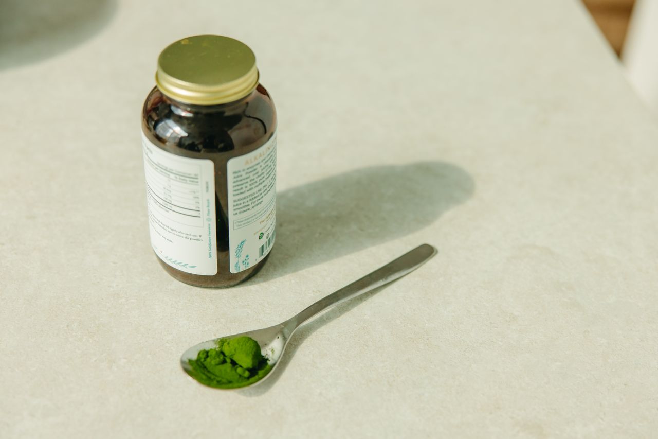 Jar and spoon with green powder