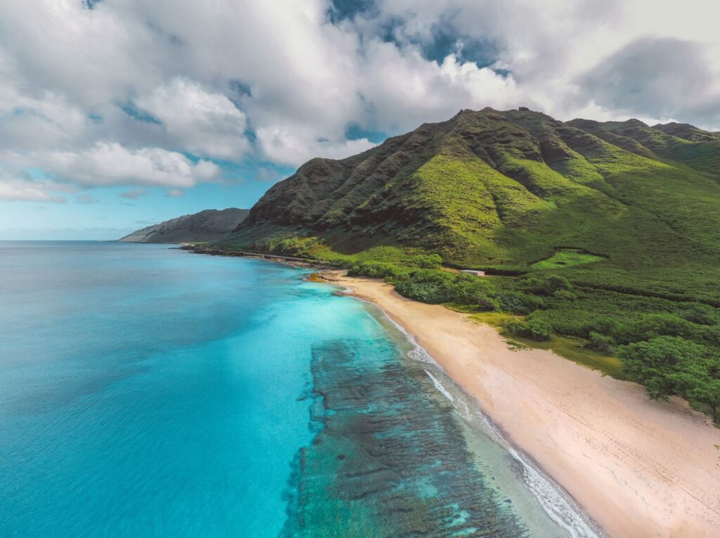 Stunning aerial view of a vibrant Hawaiian coastline with lush mountains