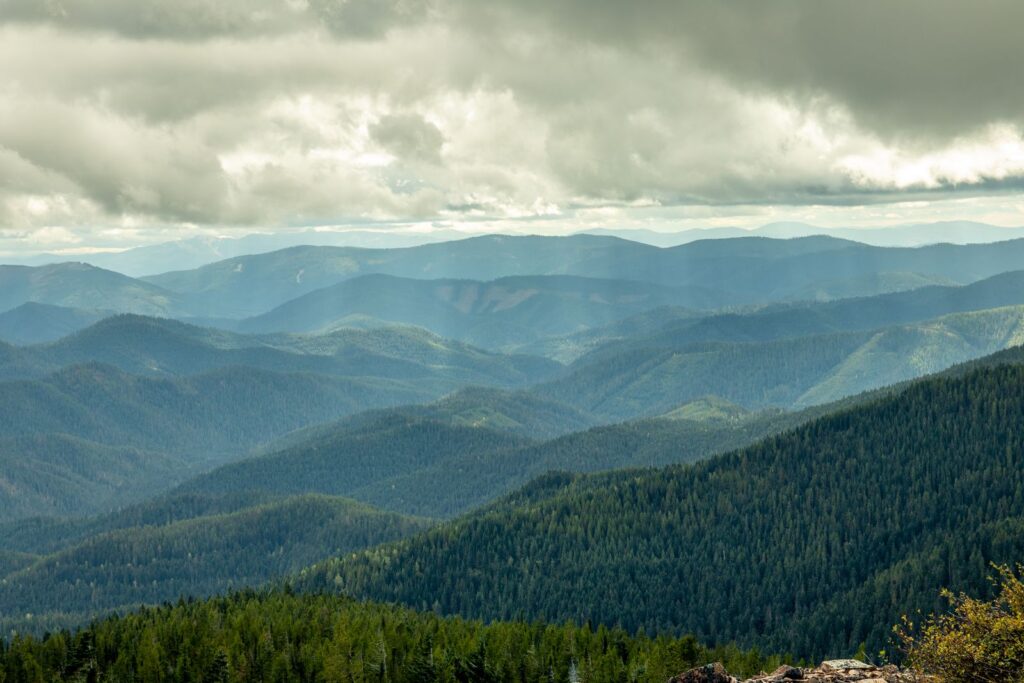 Breathtaking view of Idaho's mountain ranges with lush forests and dramatic cloudy