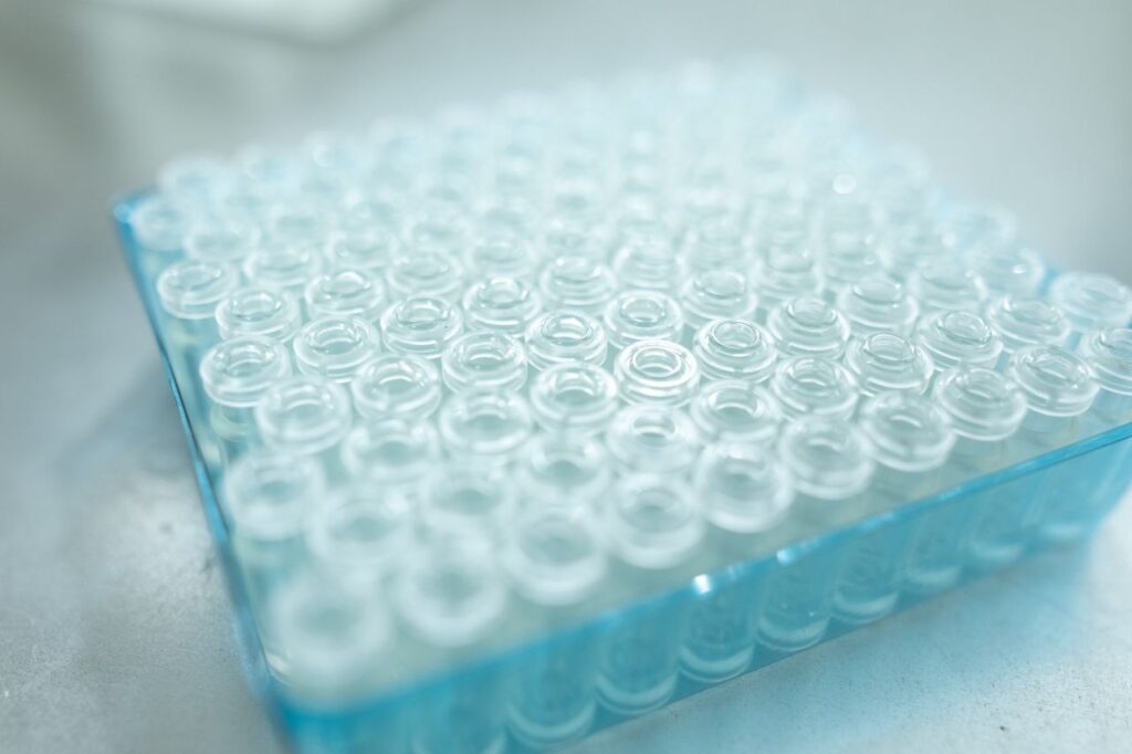 Transparent glass vials arranged in a blue tray