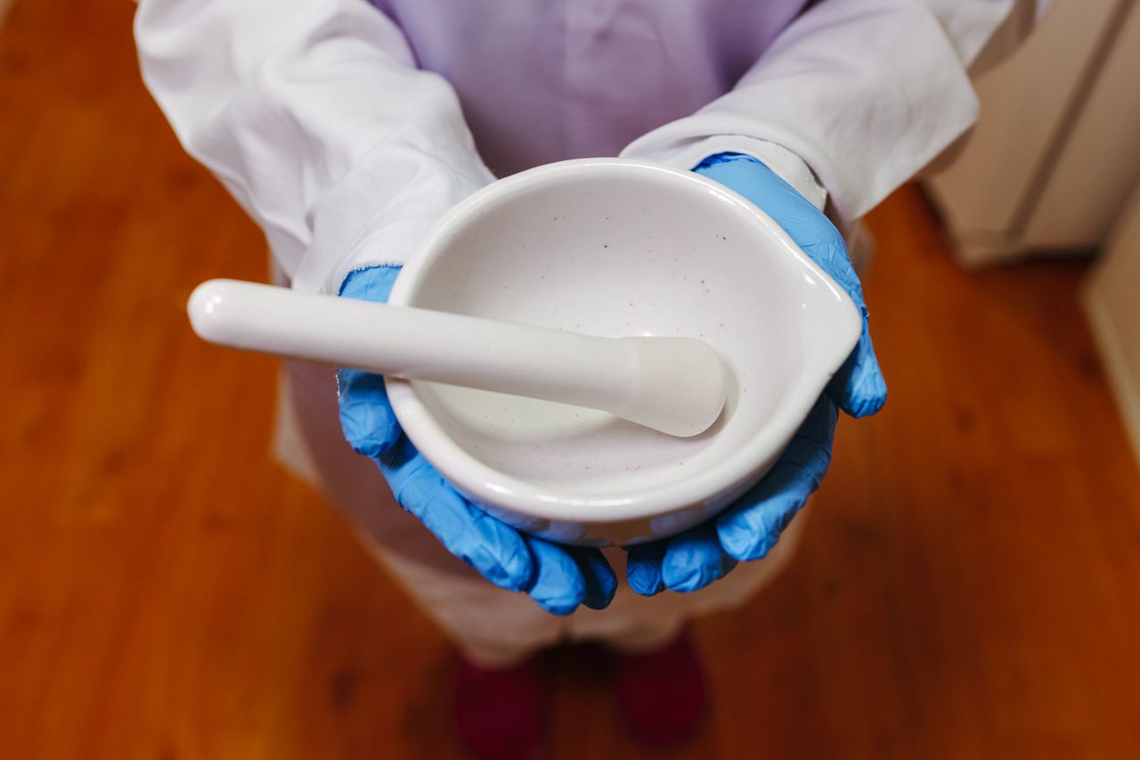 Pharmacist holding a white mortar and pestle