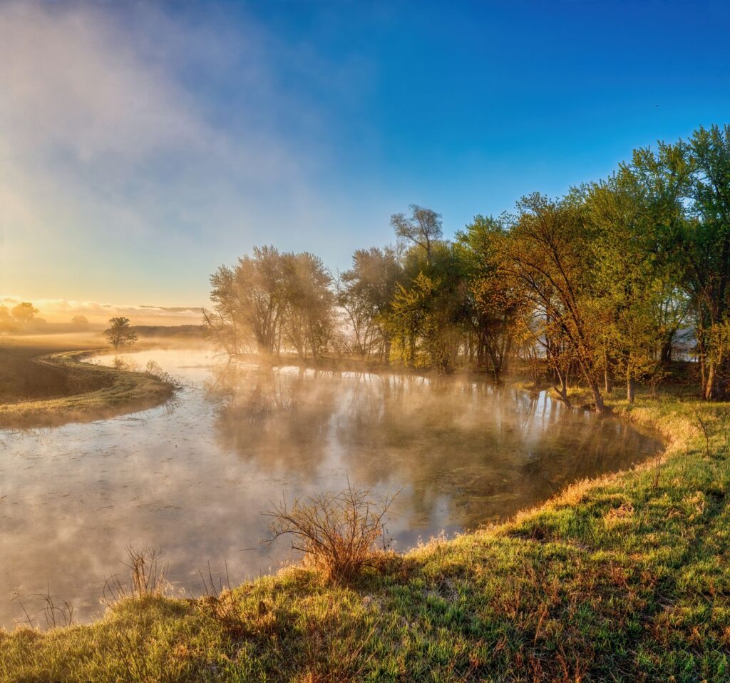 Tranquil lakeside view at sunrise with fog and autumn trees in Wabasha, Minnesota