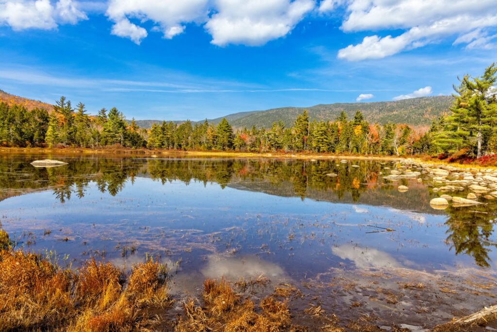 Beautiful autumn scenery of a calm lake in Lincoln, NH with vibrant fall foliage