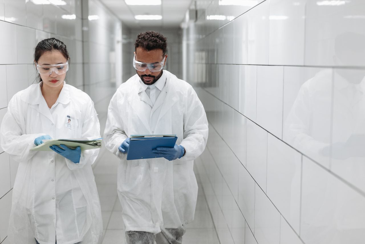 Two researchers reviewing documents in a laboratory corridor