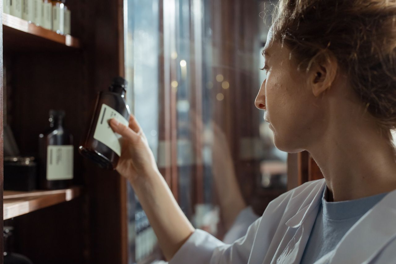 Pharmacist selecting a medication bottle from a shelf