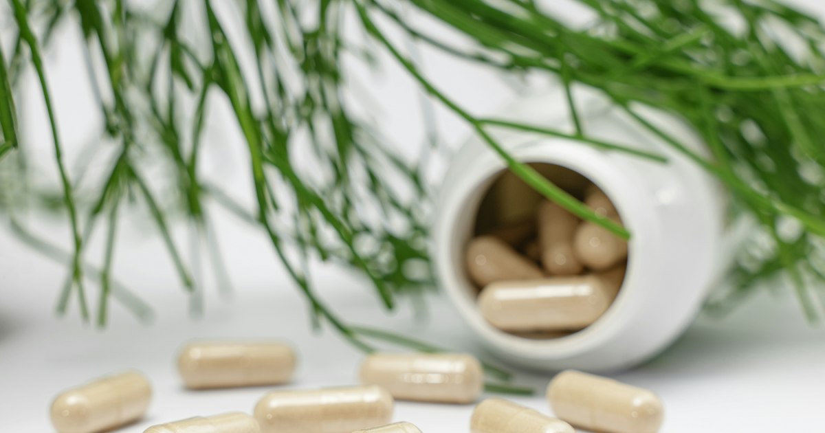 Supplement capsules spilling from a white bottle