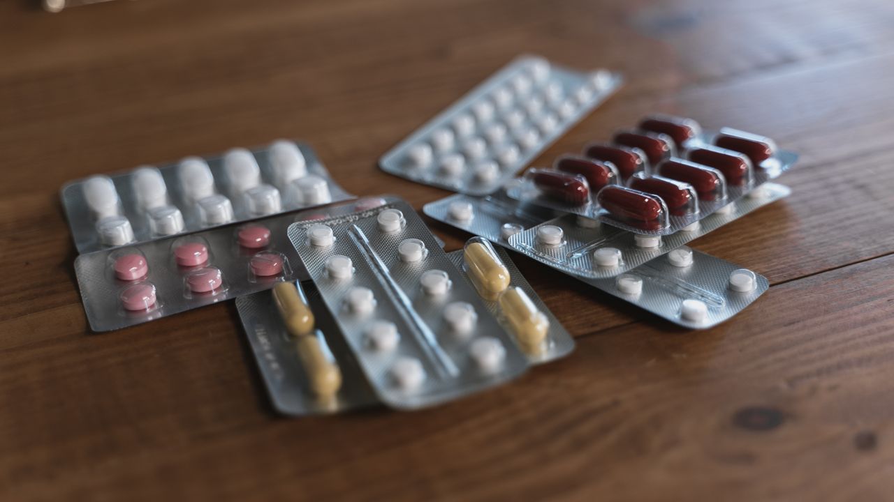 Assorted blister packs of tablets on a wooden table