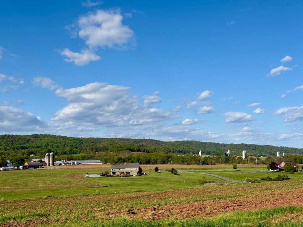 A picturesque view of Pennsylvania farmland under a clear blue sky with rolling