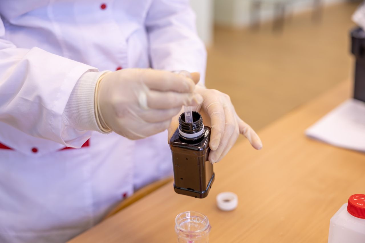 Scientist extracting a liquid sample in a laboratory