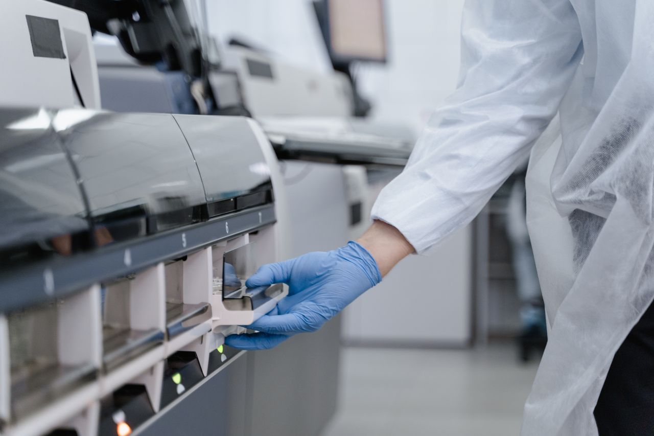 Lab technician using equipment in a sterile laboratory
