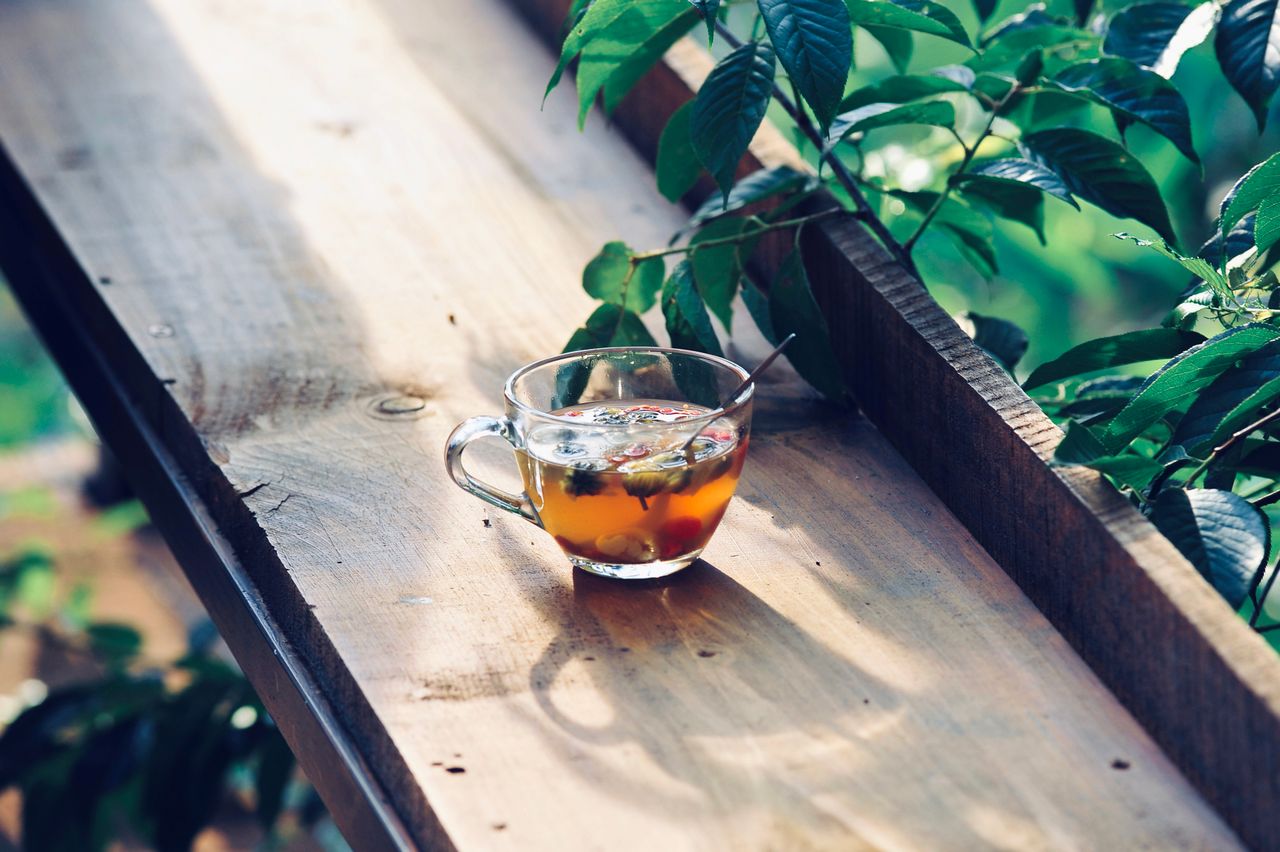Cup of herbal tea on a sunlit wooden table