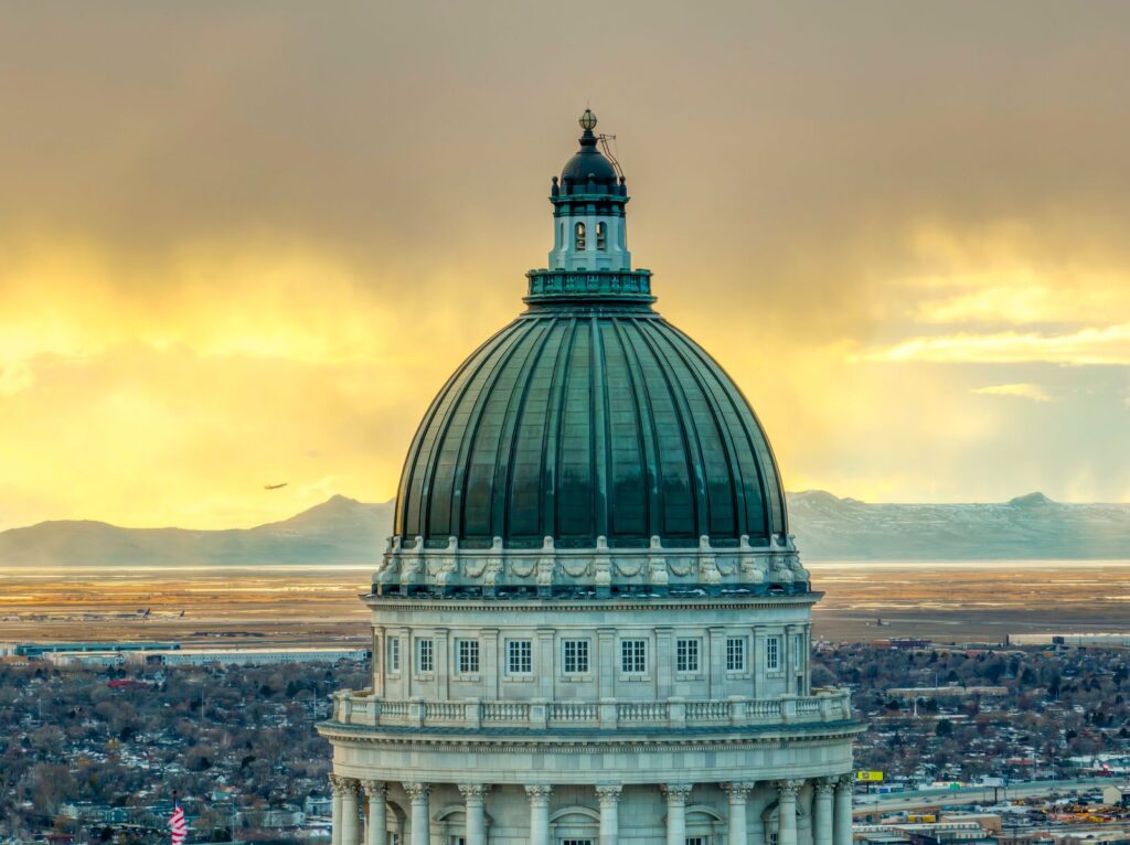 Majestic view of the Utah State Capitol dome with a vibrant sunset backdrop in Salt