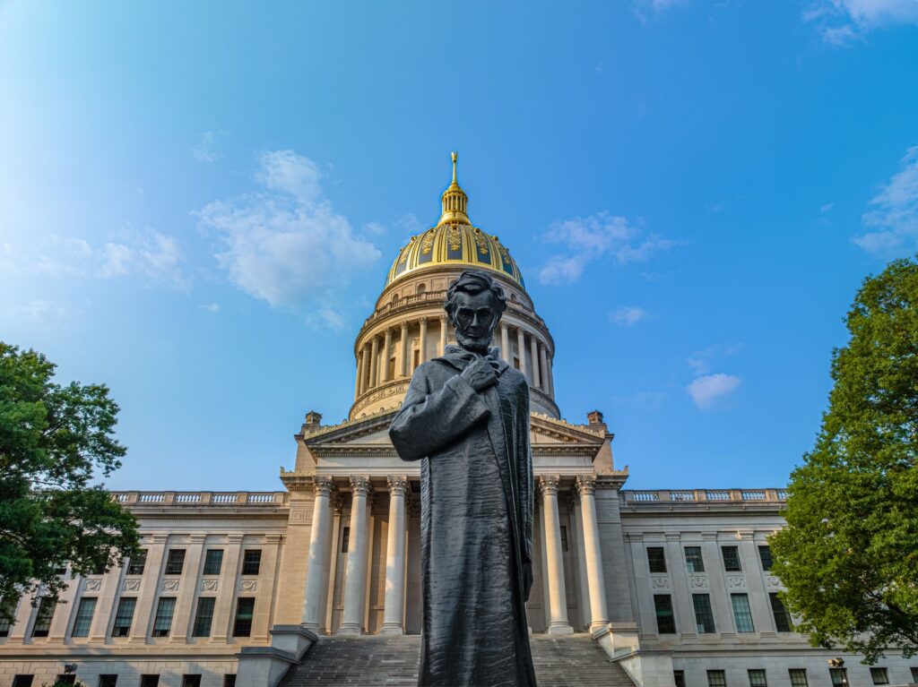 Facade of the West Virginia State Capitol building with a statue of Abraham Lincoln