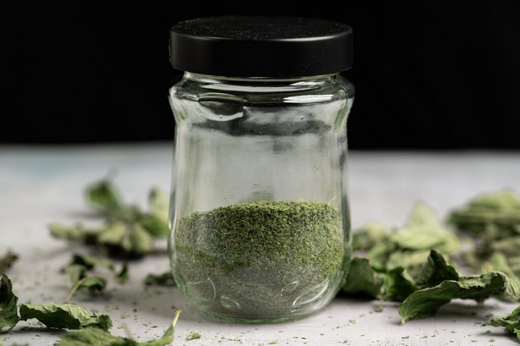 Glass jar filled with green powdered leaves