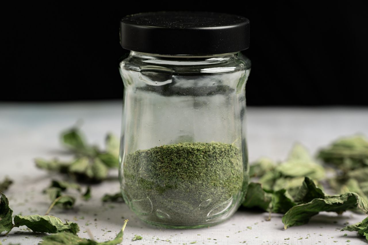 Glass jar filled with green powdered leaves