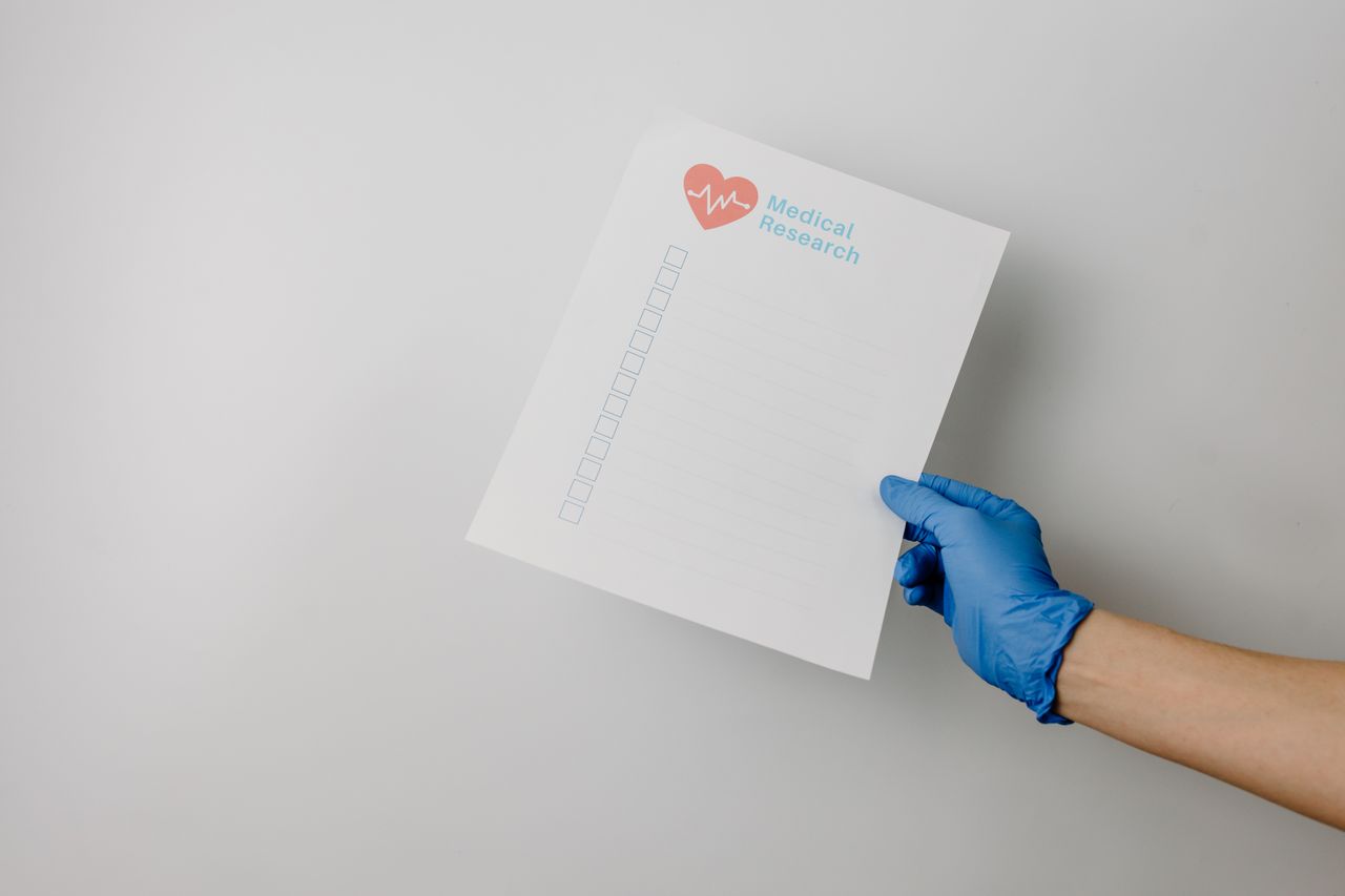 Gloved hand holding a research checklist